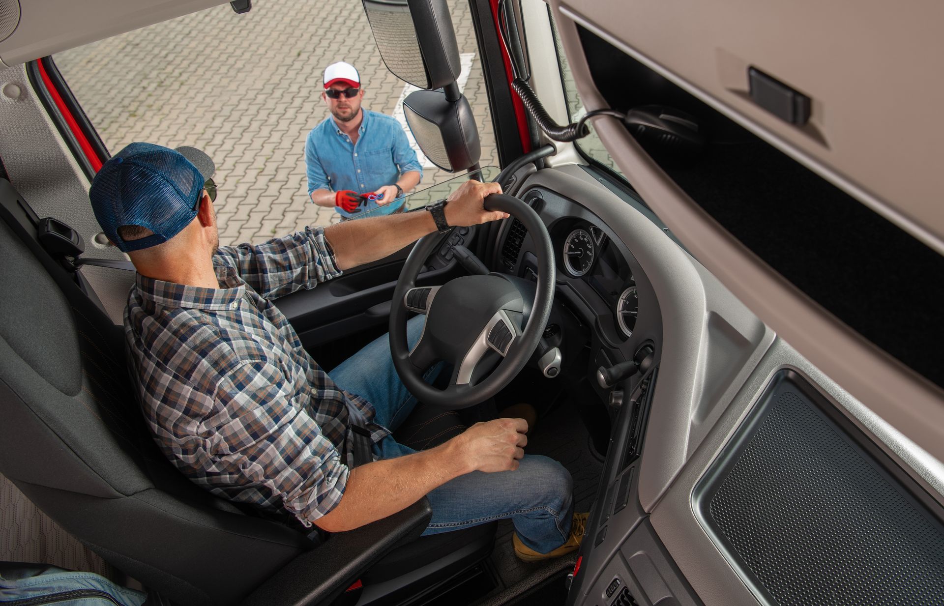 A man is sitting in the driver 's seat of a semi truck.