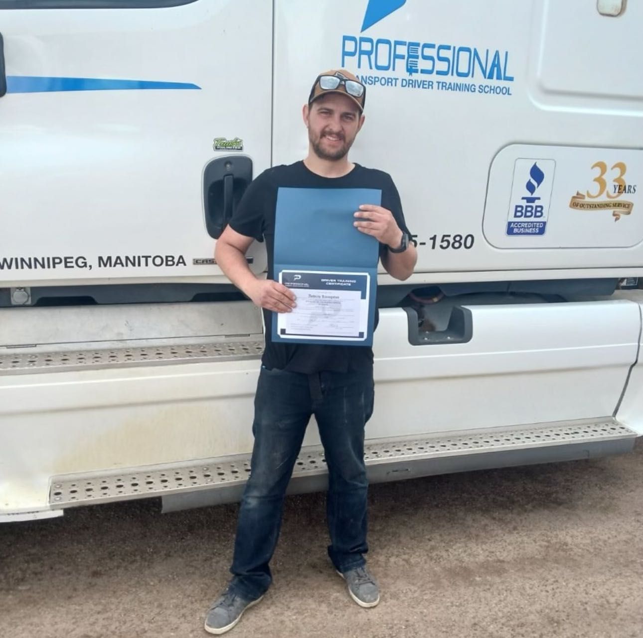 A man is standing in front of a professional truck