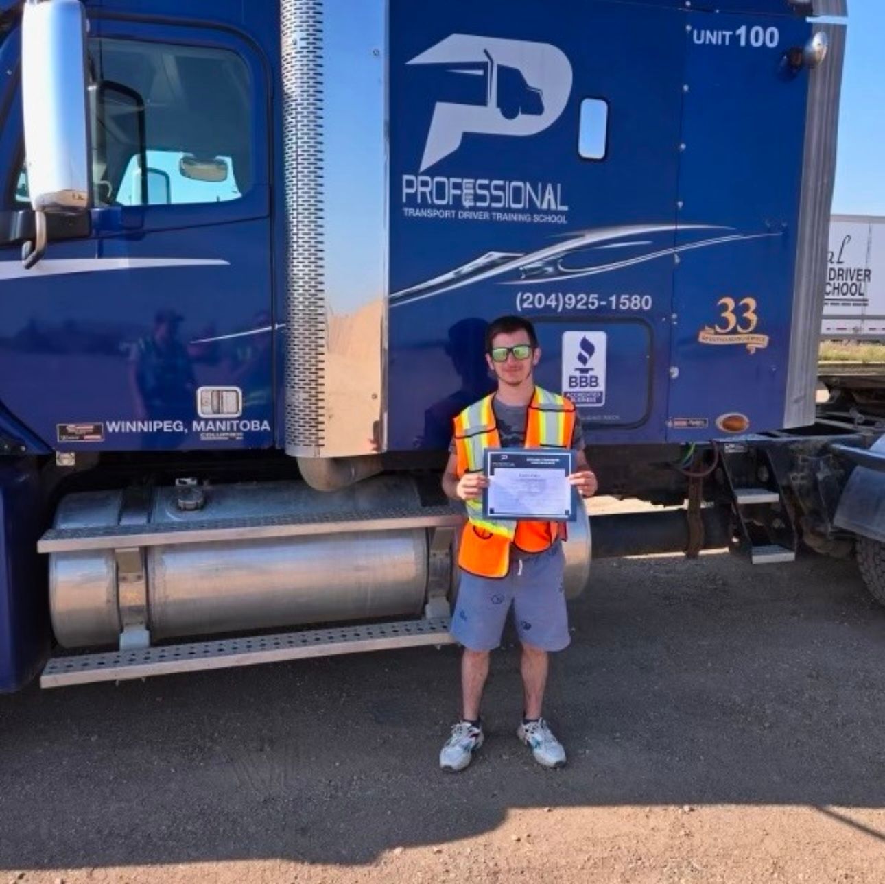 A man standing in front of a blue truck that says professional
