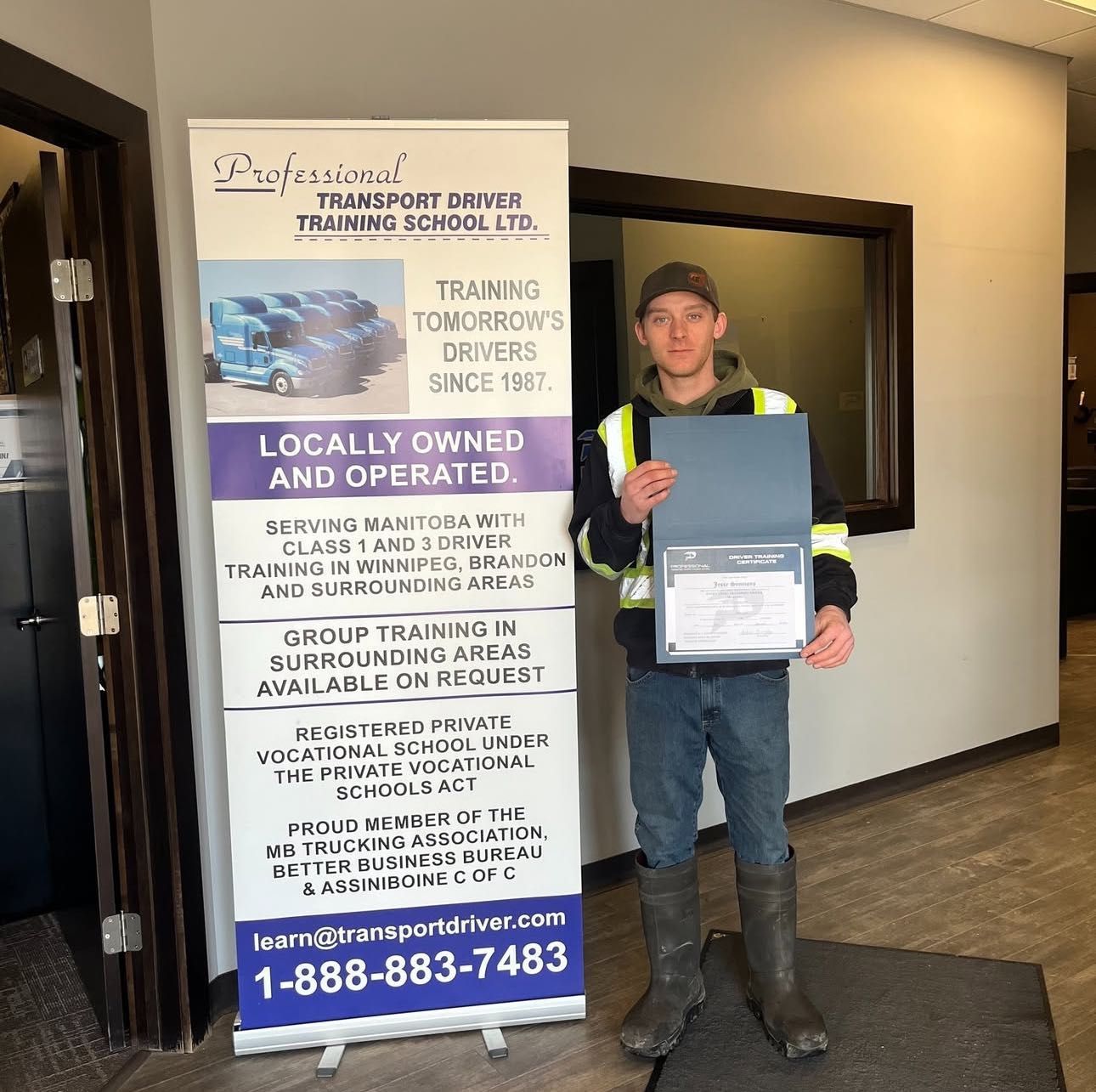 A man standing in front of a sign that says locally owned and operated
