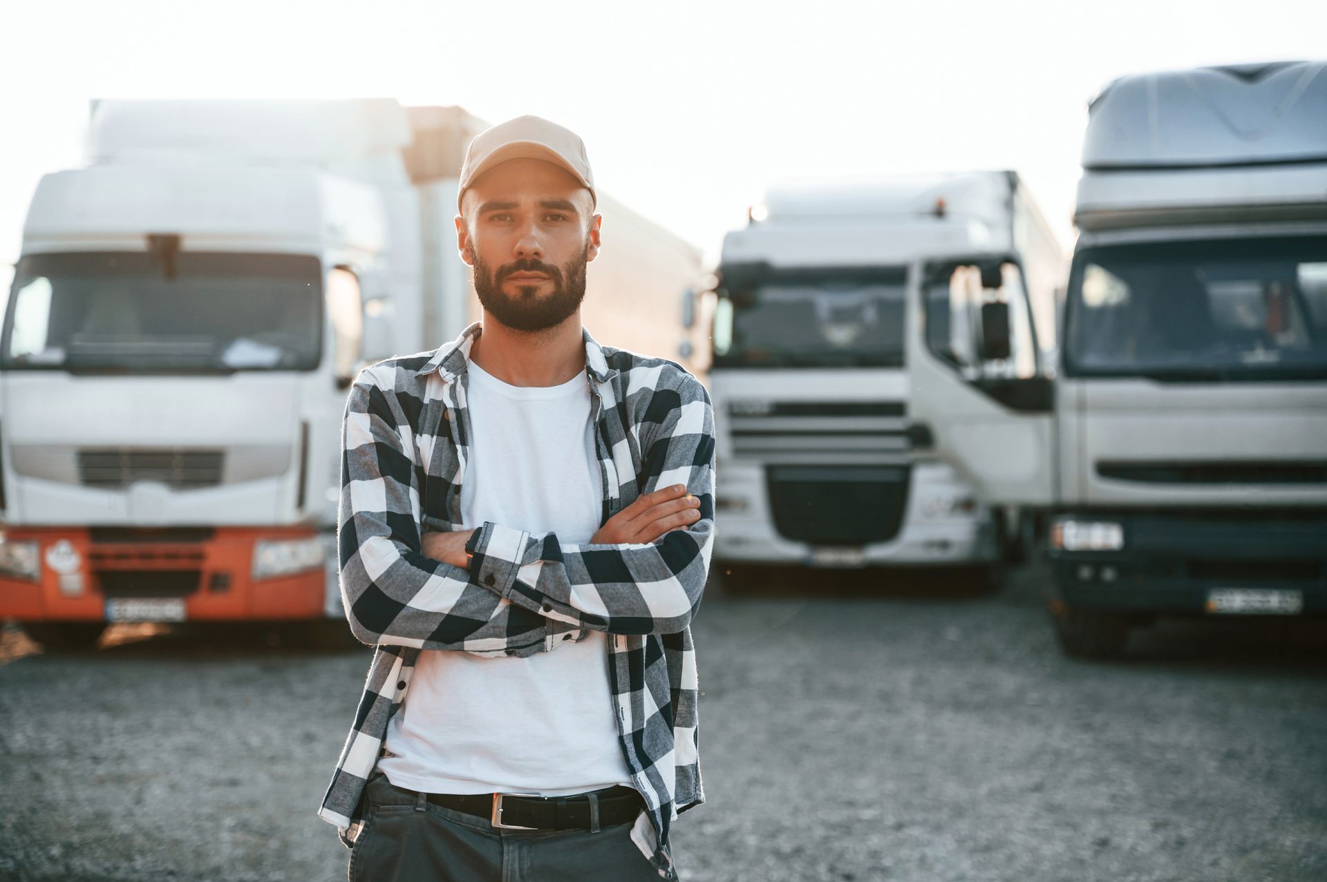 a man is standing in front of a row of semi trucks .