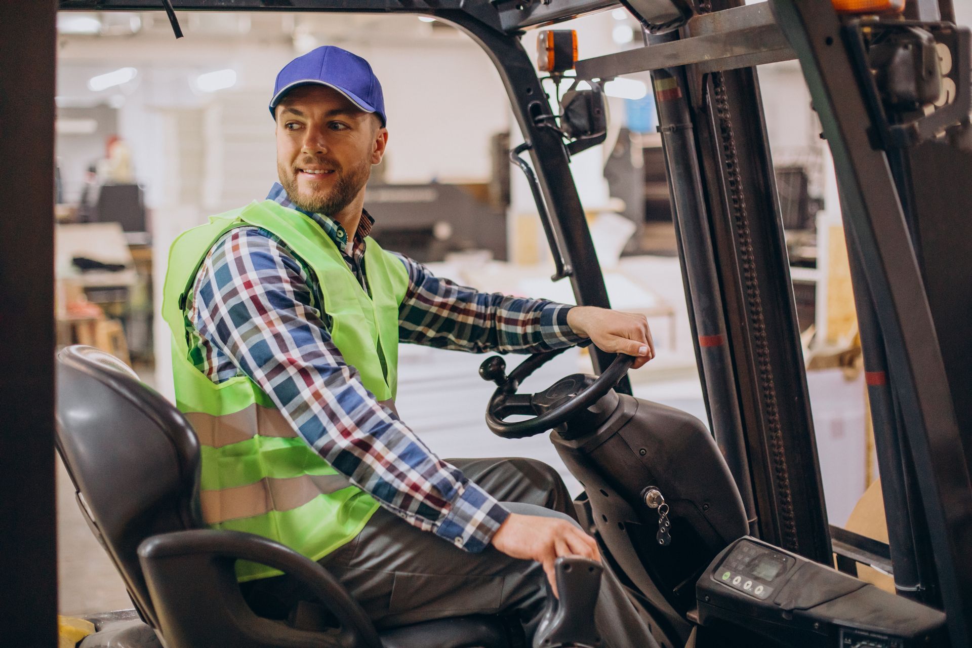 a man is sitting in a forklift in a factory .