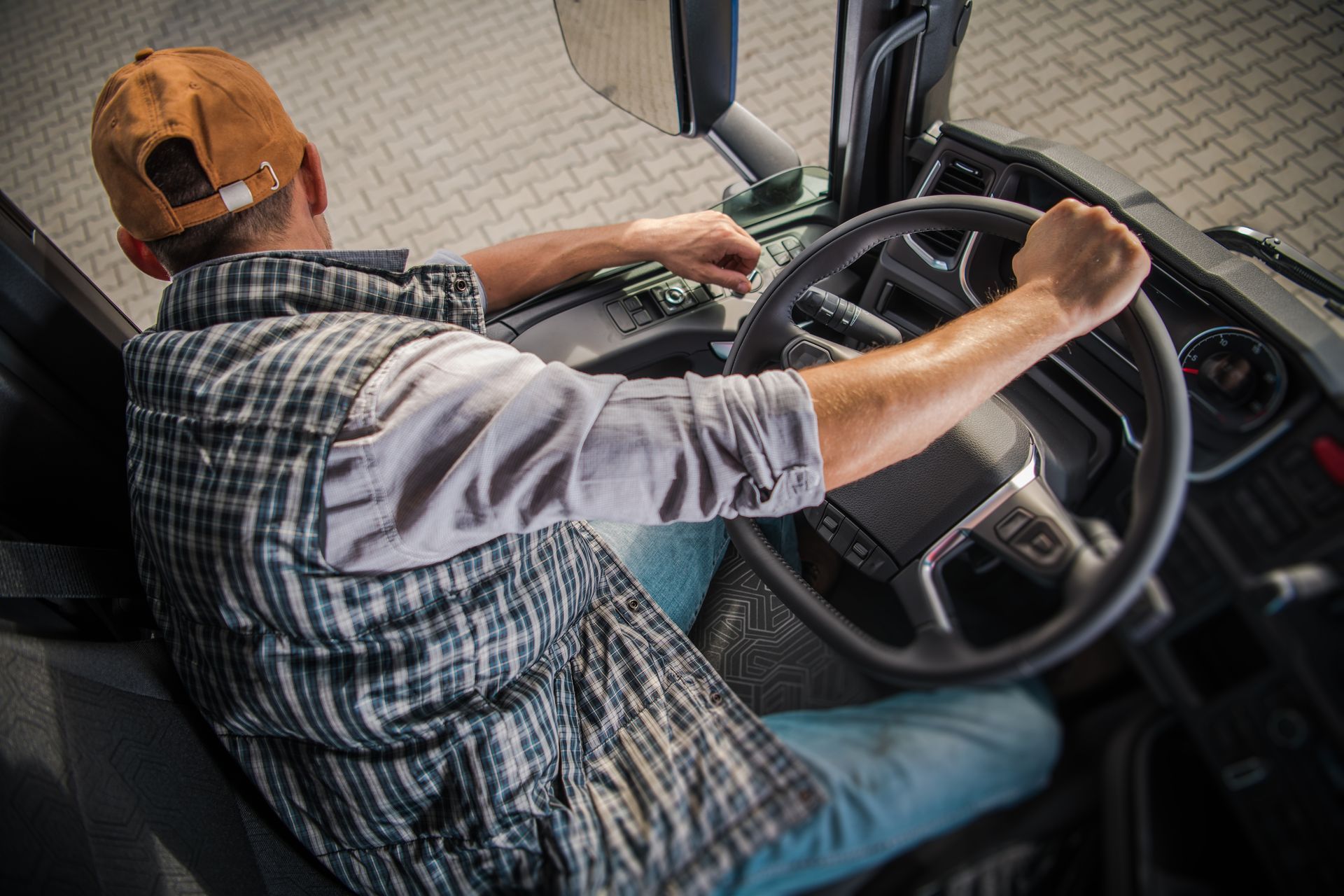 a man is sitting in the driver 's seat of a truck .