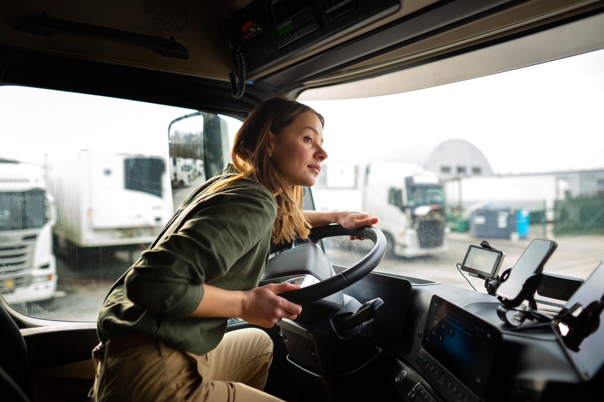 a woman is sitting in the driver 's seat of a truck .