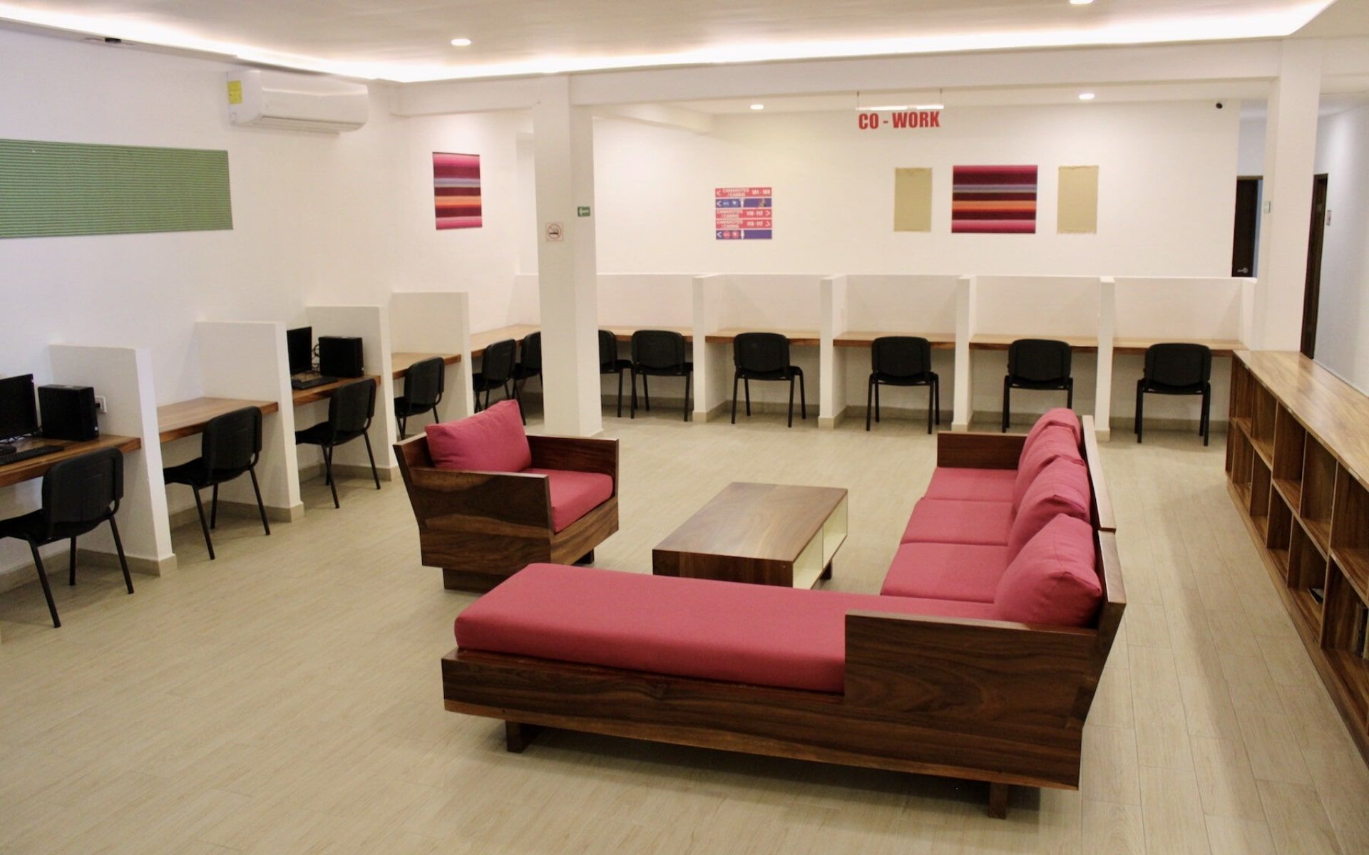 A living room with a couch , chairs , and computers.