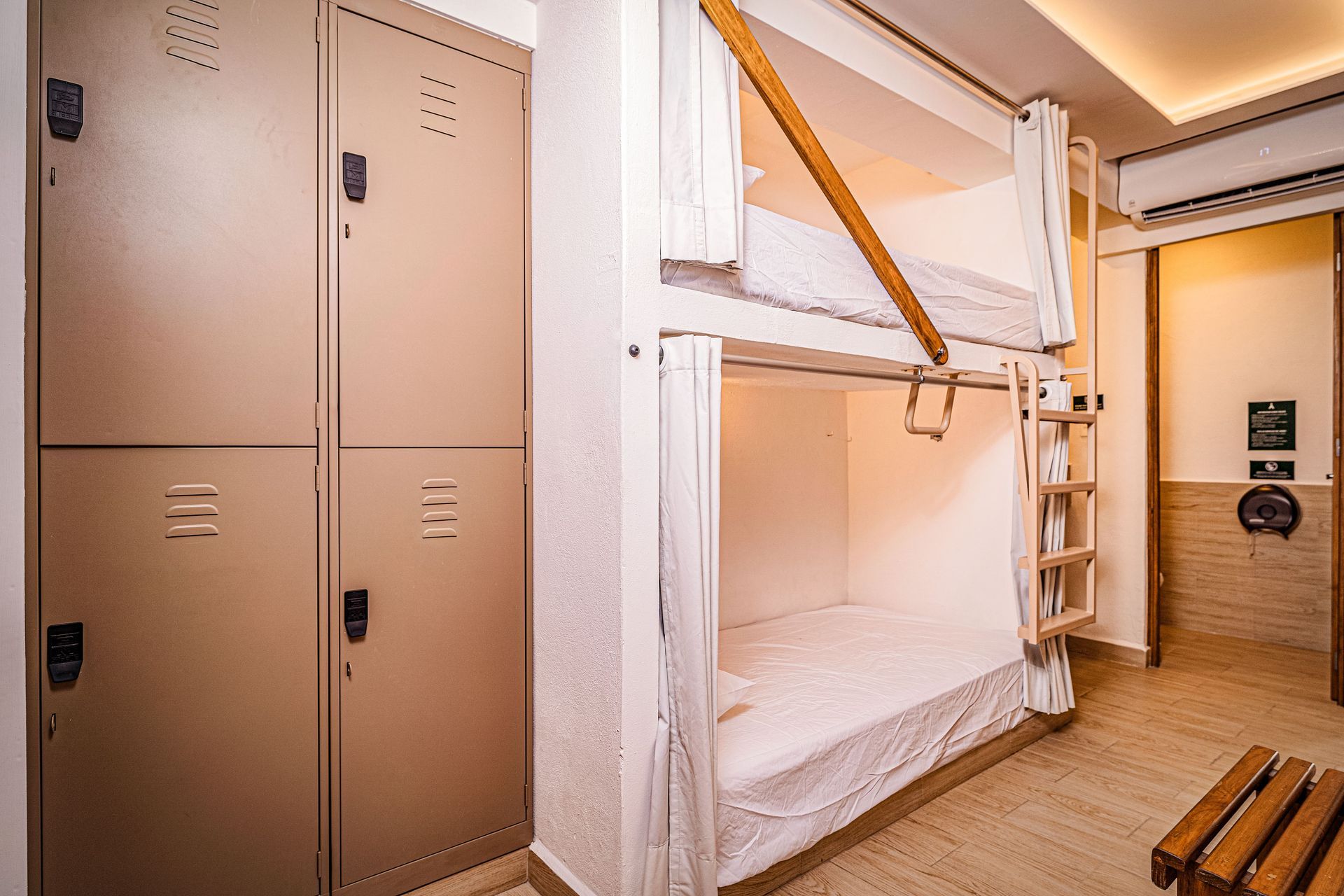 A bunk bed with a ladder in a room with lockers.