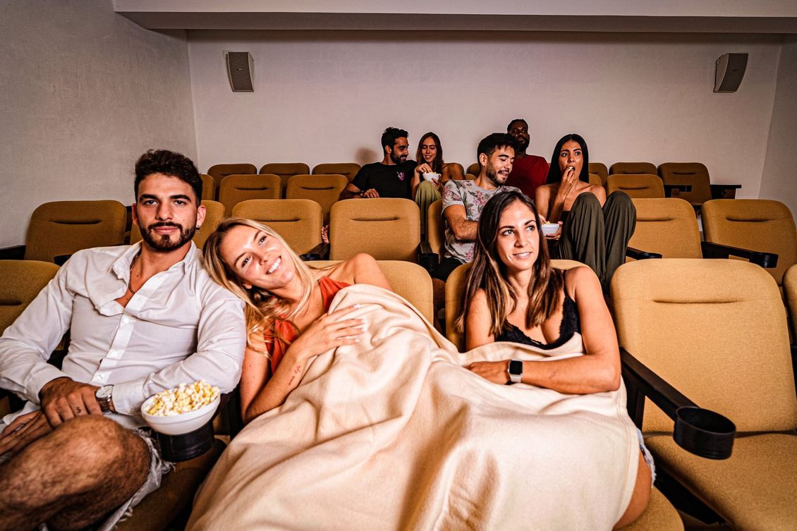 A group of people are sitting in a theater watching a movie.