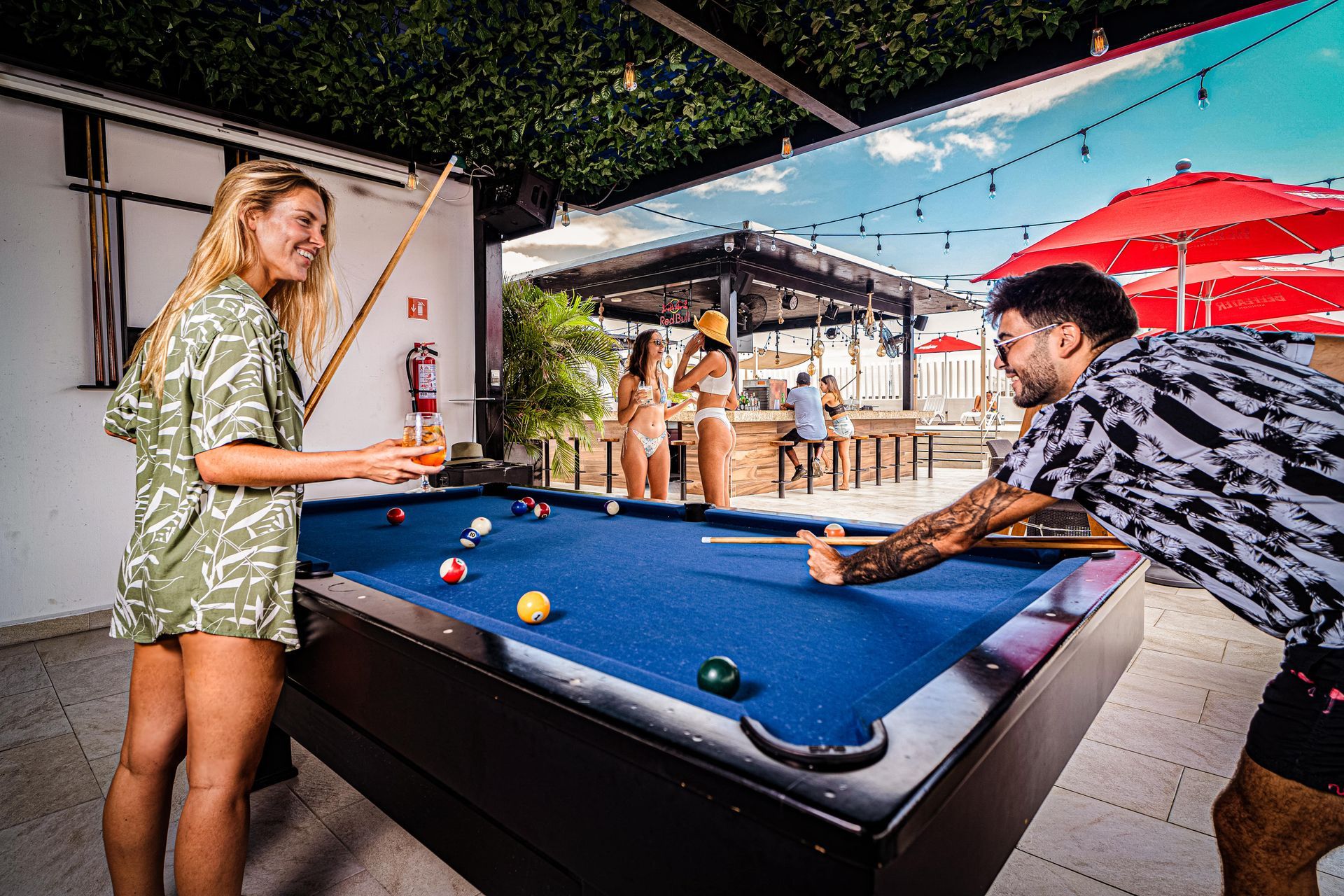 A man and a woman are playing pool on a pool table.