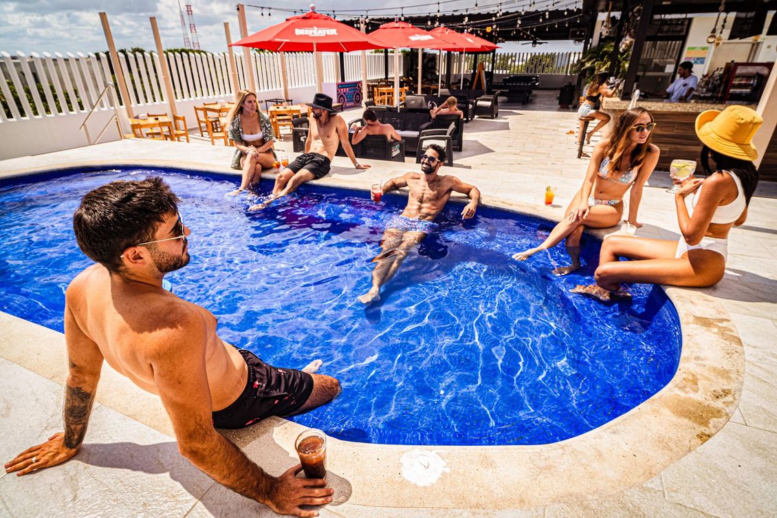 A group of people are sitting around a swimming pool.