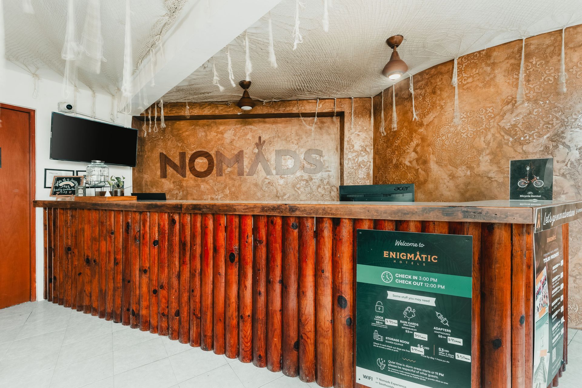 A hotel lobby with a wooden counter and a sign that says nomad.