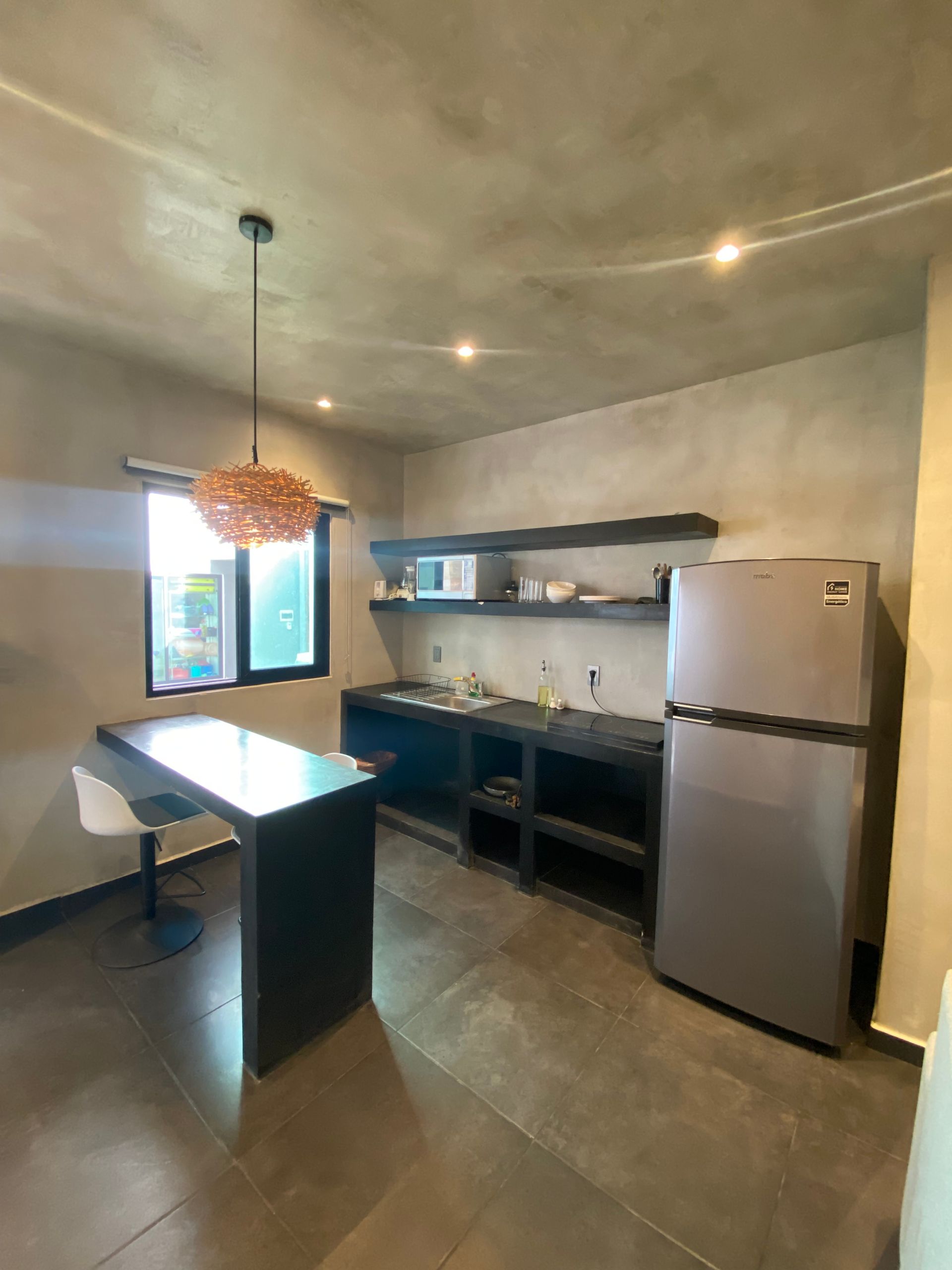 A kitchen with a refrigerator , sink , table and chairs.