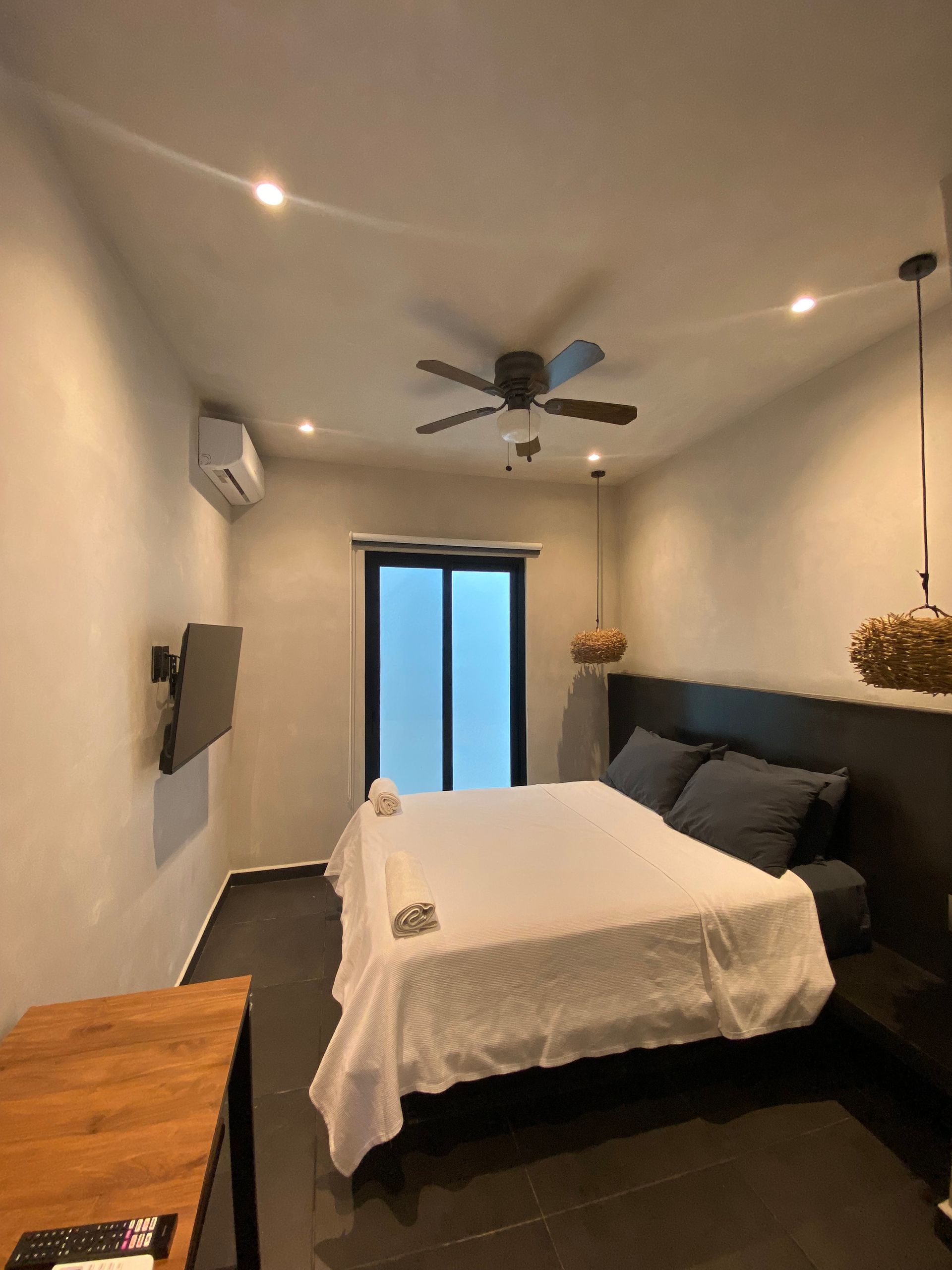 A bedroom with a large bed and a ceiling fan