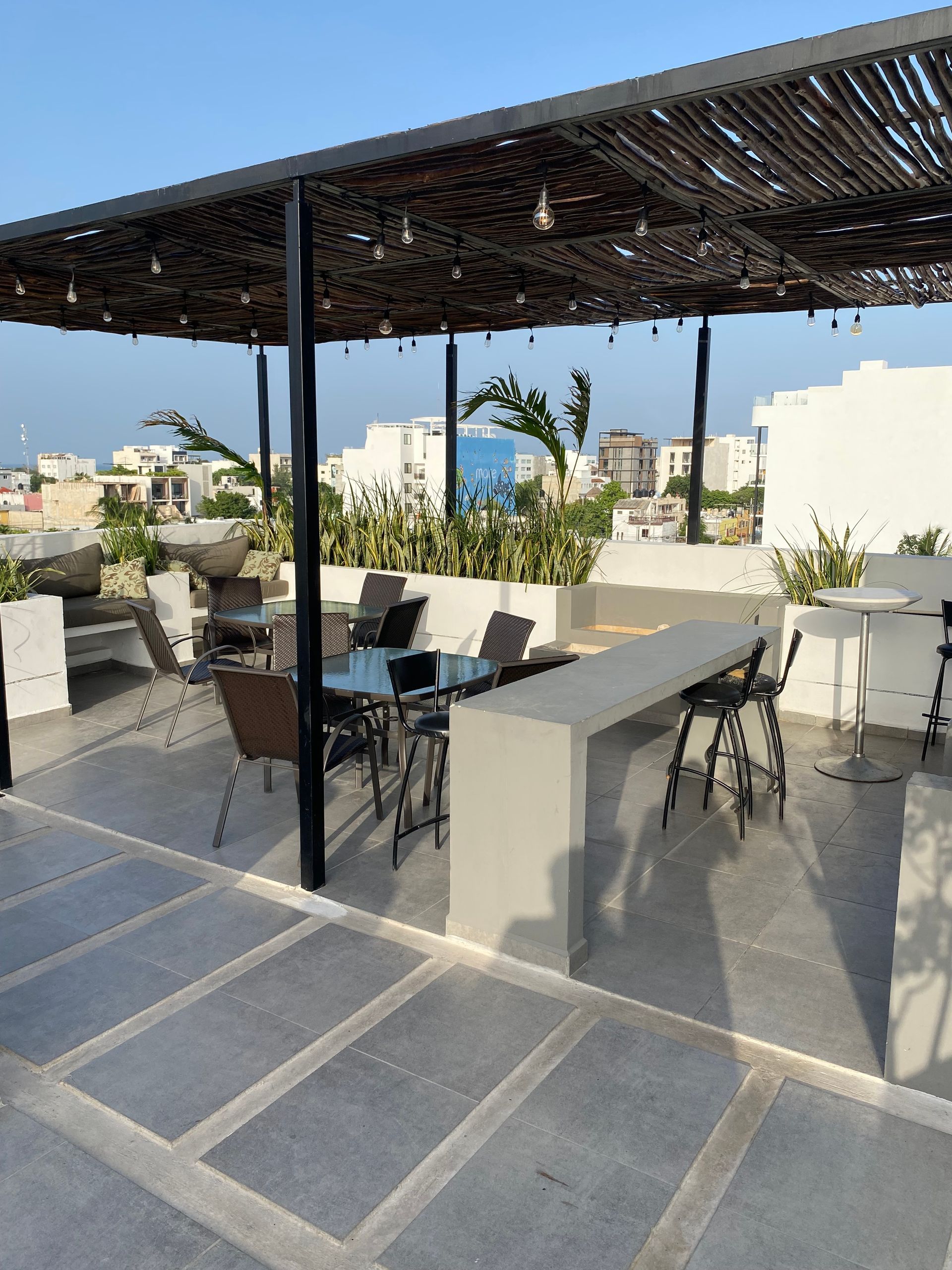 A patio with tables and chairs under a canopy