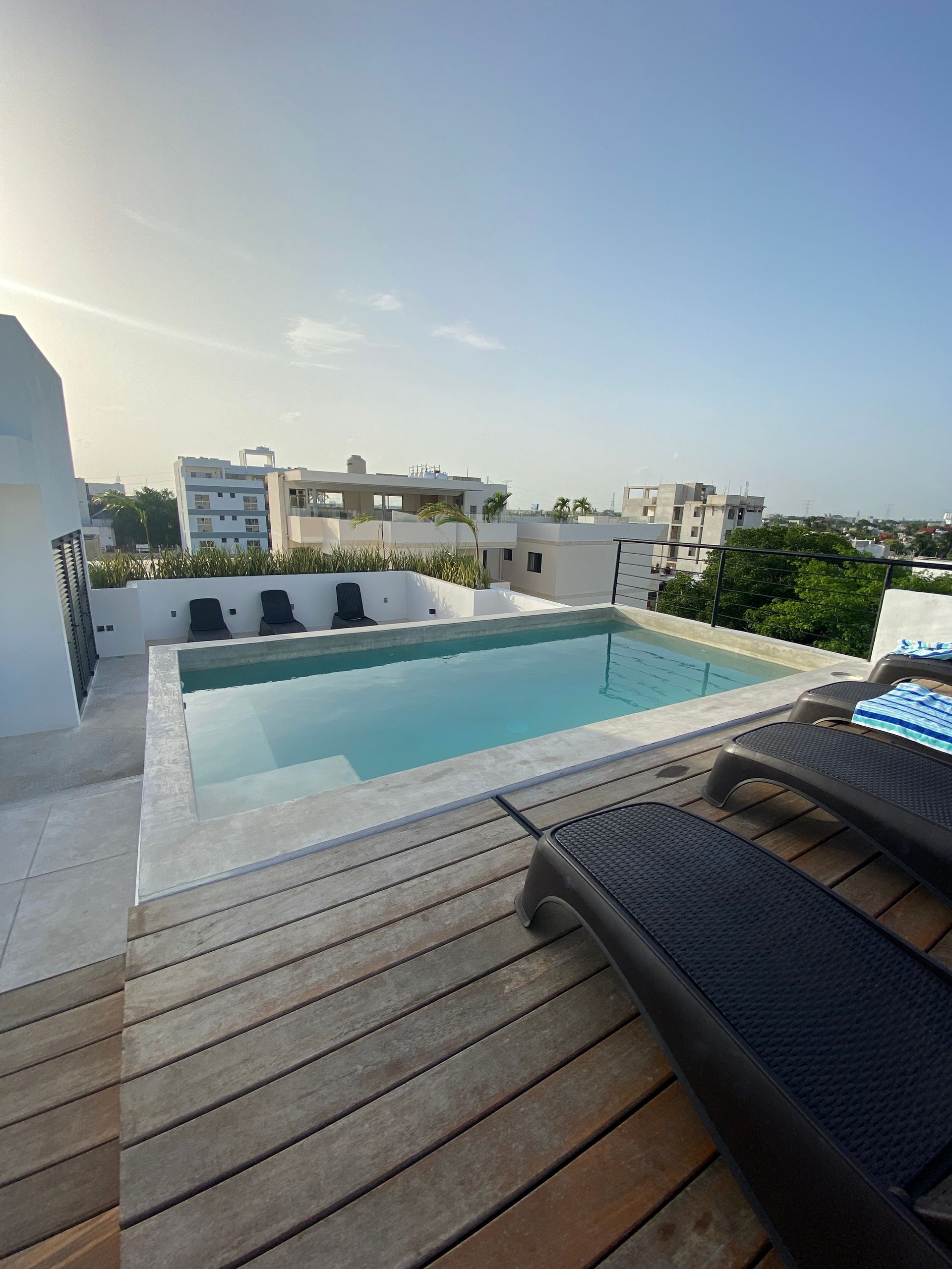 There is a large swimming pool on the roof of a building.