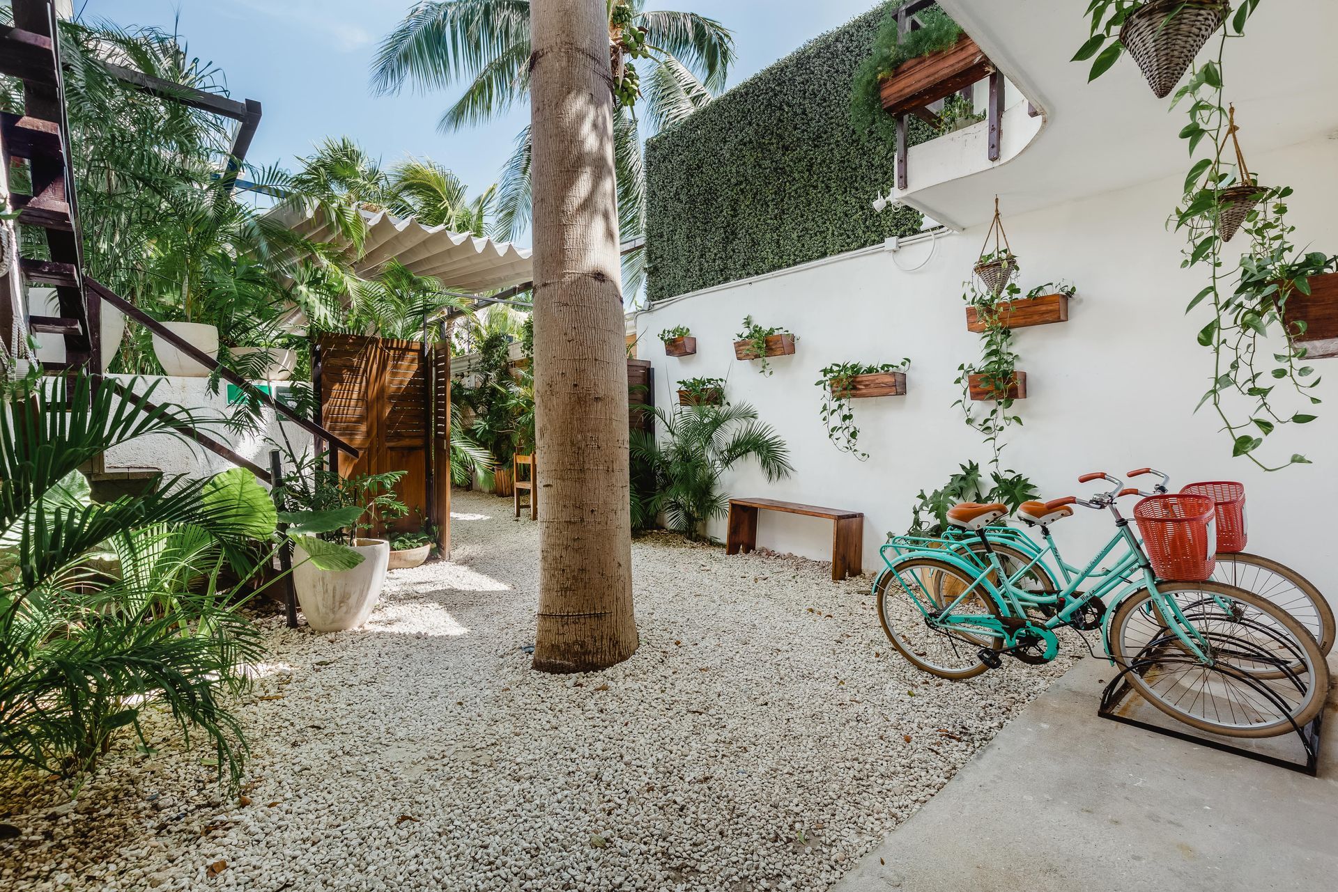 Two bicycles are parked in front of a white building.