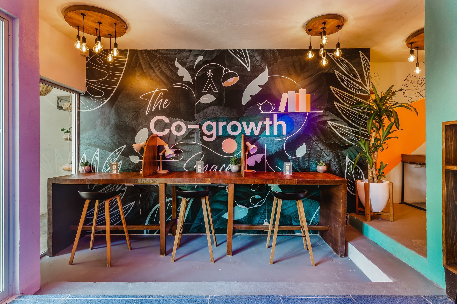 A room with a chalkboard wall and a table and stools.