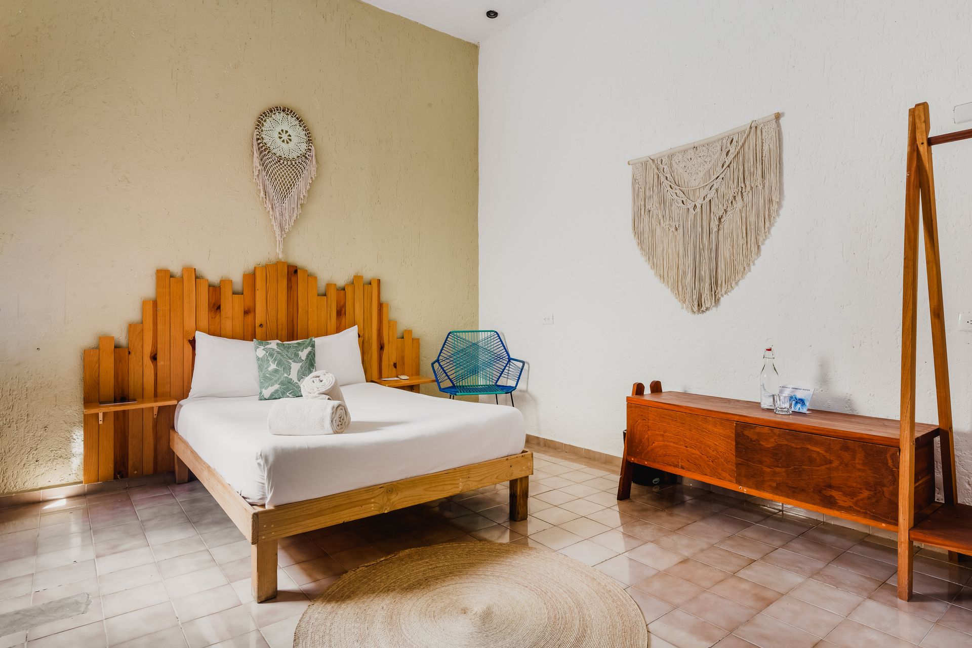 A bedroom with a wooden bed and a dream catcher on the wall.