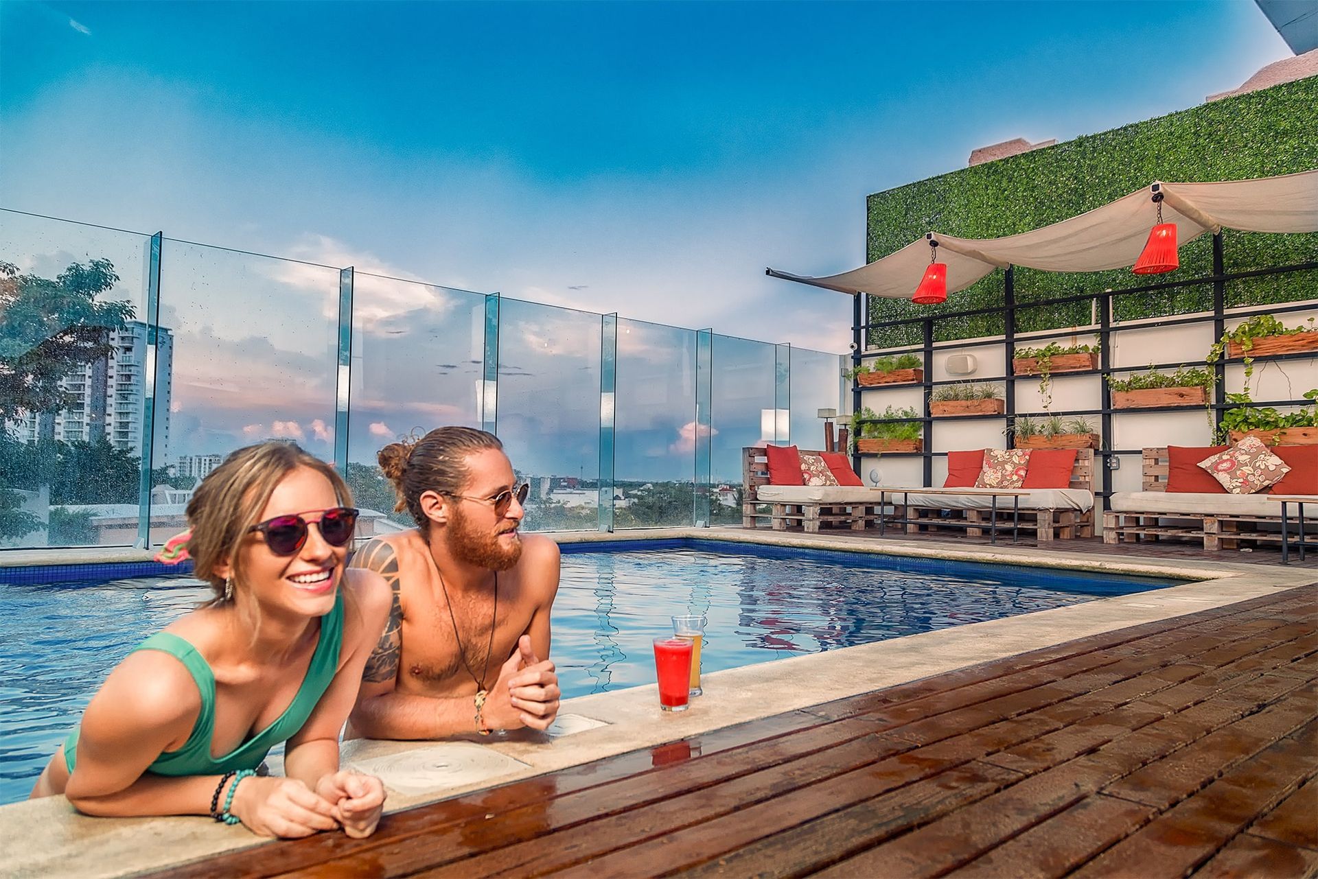 A man and a woman are sitting on the edge of a swimming pool.