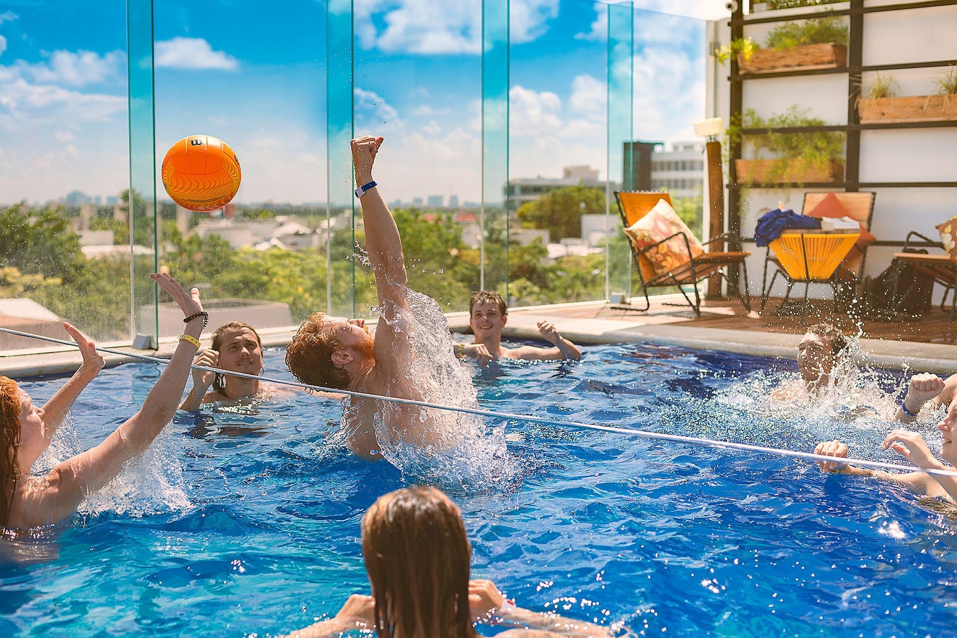 A group of people are playing volleyball in a swimming pool.
