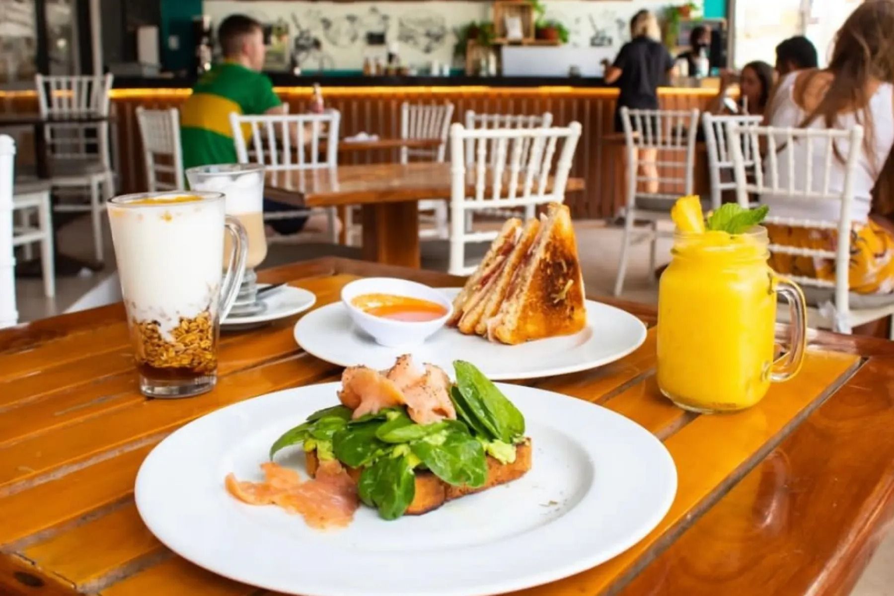 A wooden table topped with plates of food and drinks.