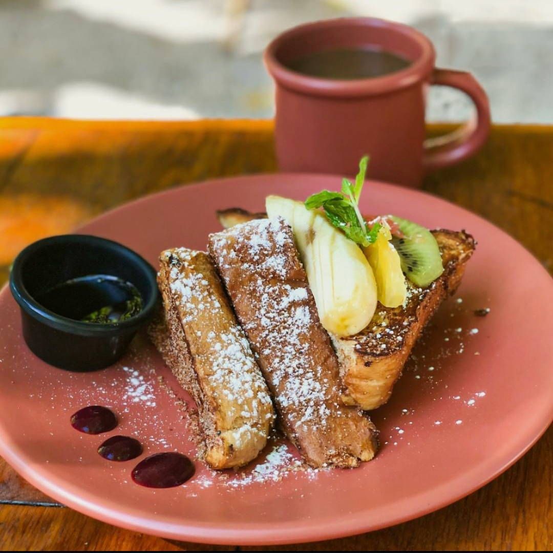 A plate of food with a cup of coffee in the background