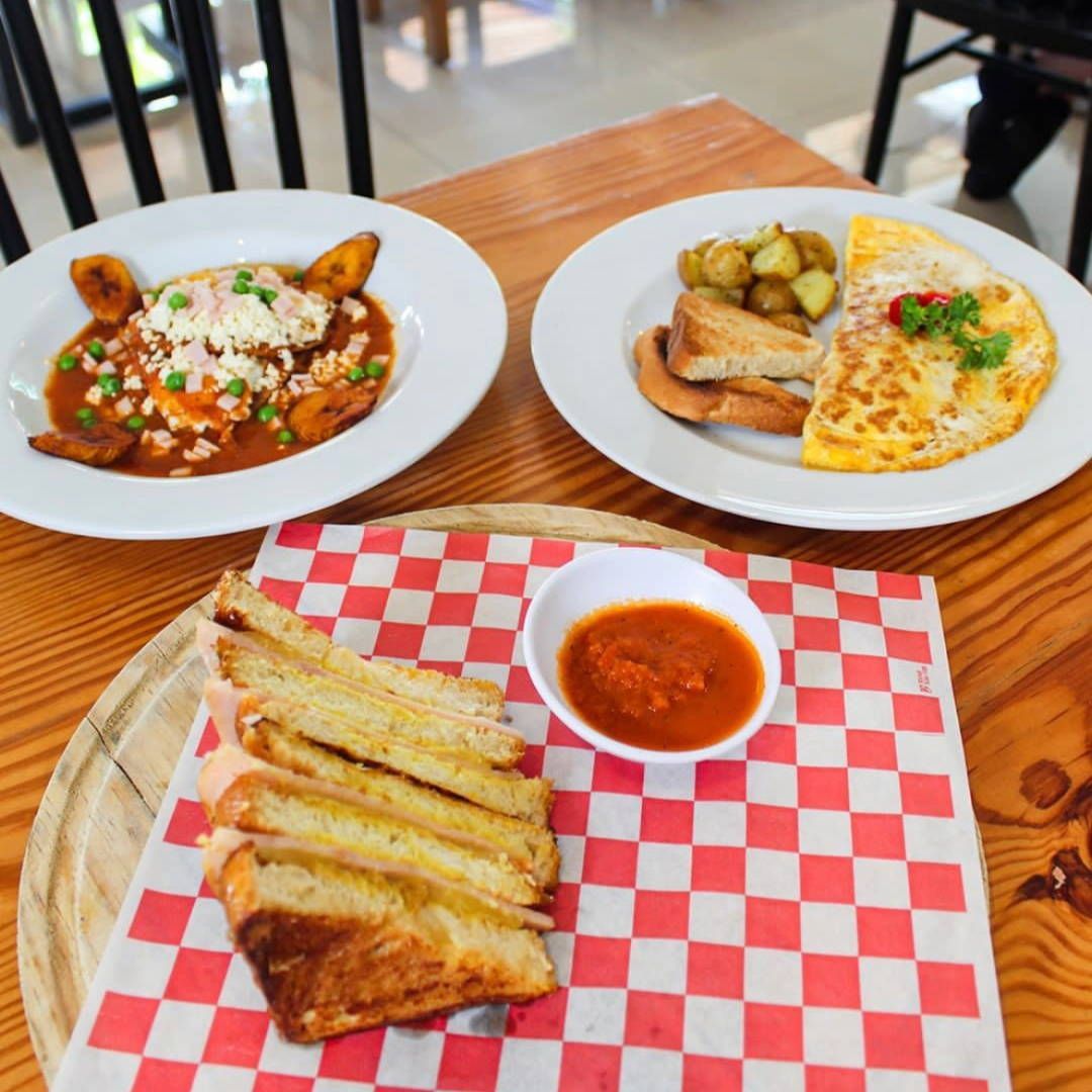 Two plates of food on a checkered paper on a wooden table