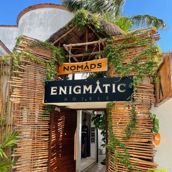 A sign for nomads enigmatic hotels hangs above the entrance