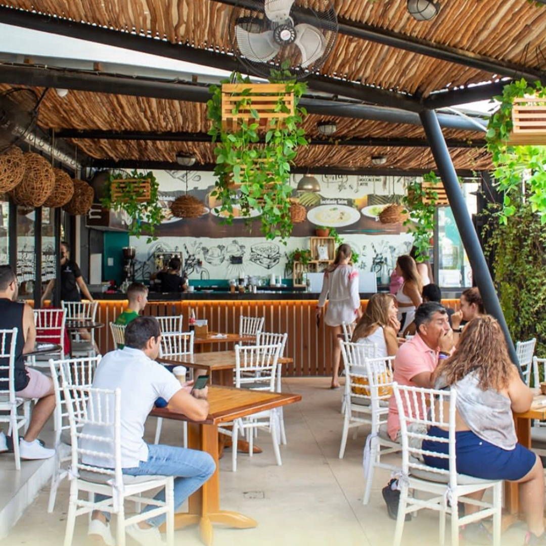 A group of people are sitting at tables in a restaurant.