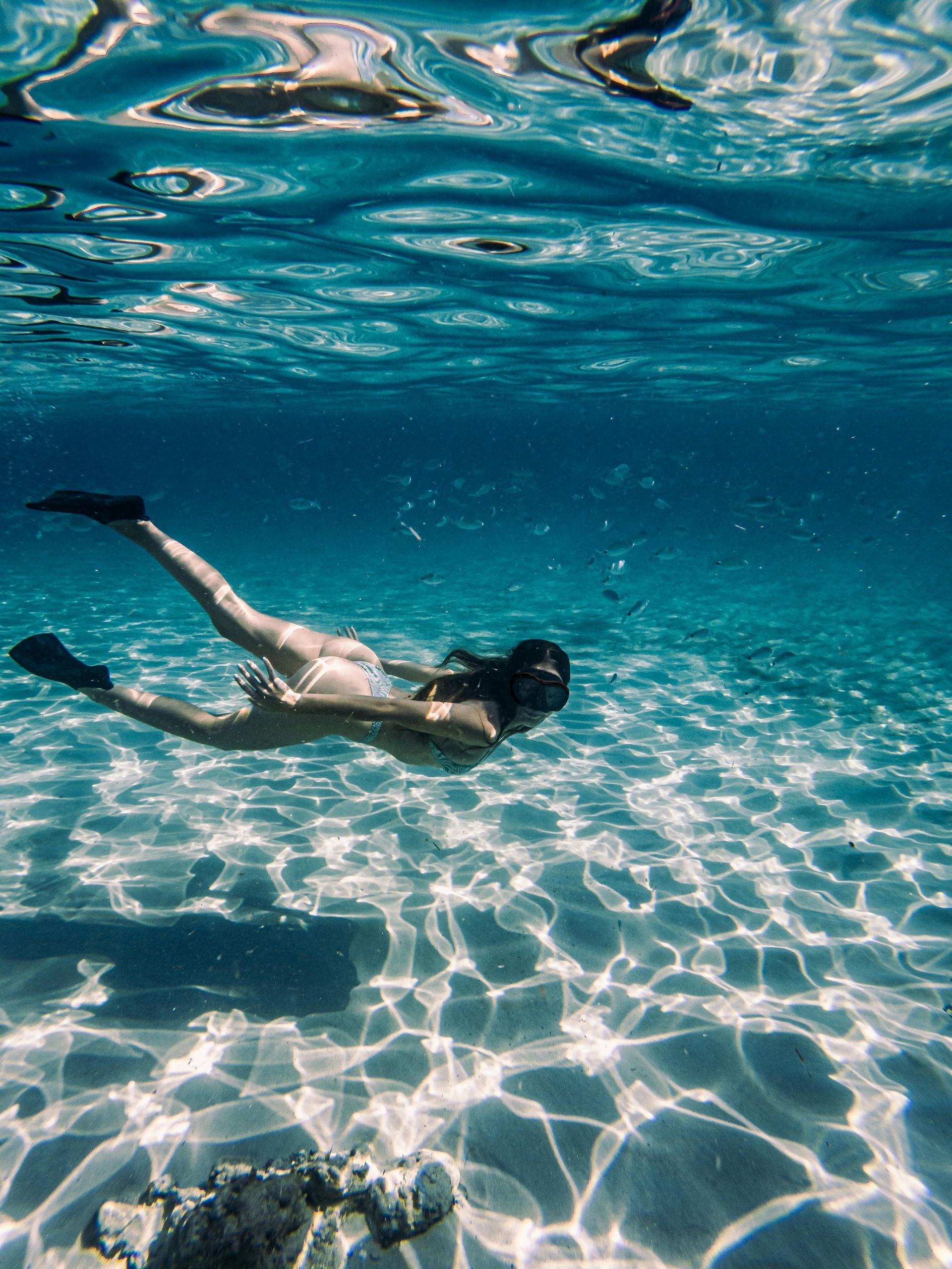 A scuba diver is giving the ok sign in the ocean.