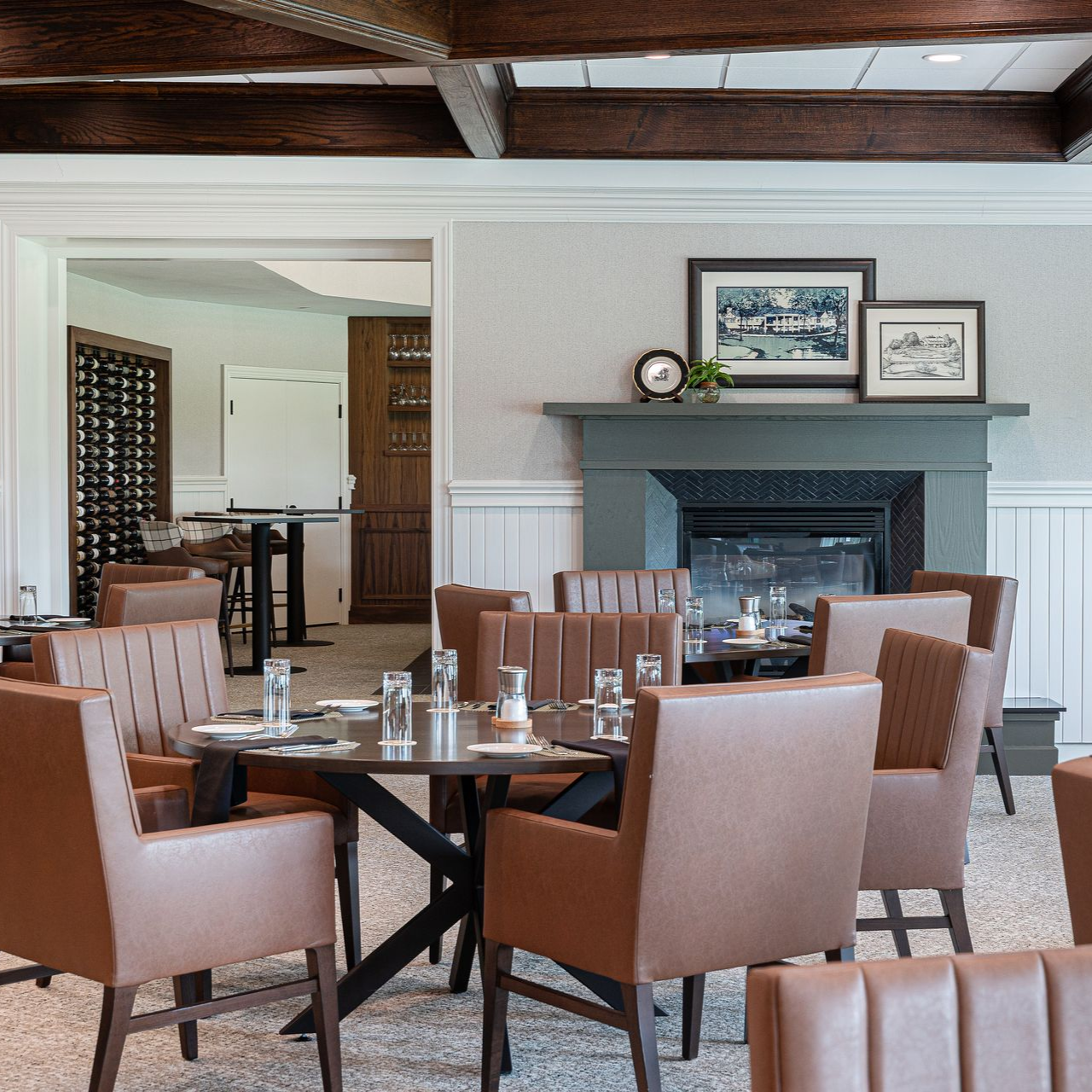 Dining room with dark furniture, blue rug, and decorative pendant lights.