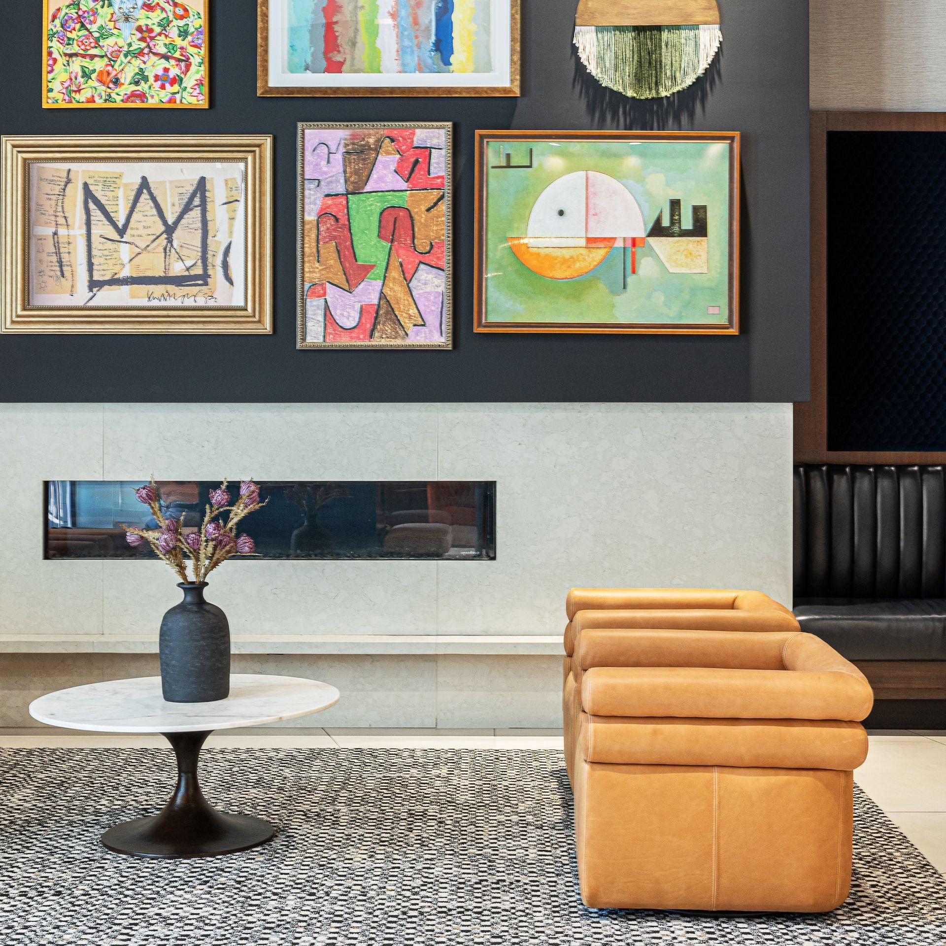 Modern living room with artwork, tan chairs, and round table.