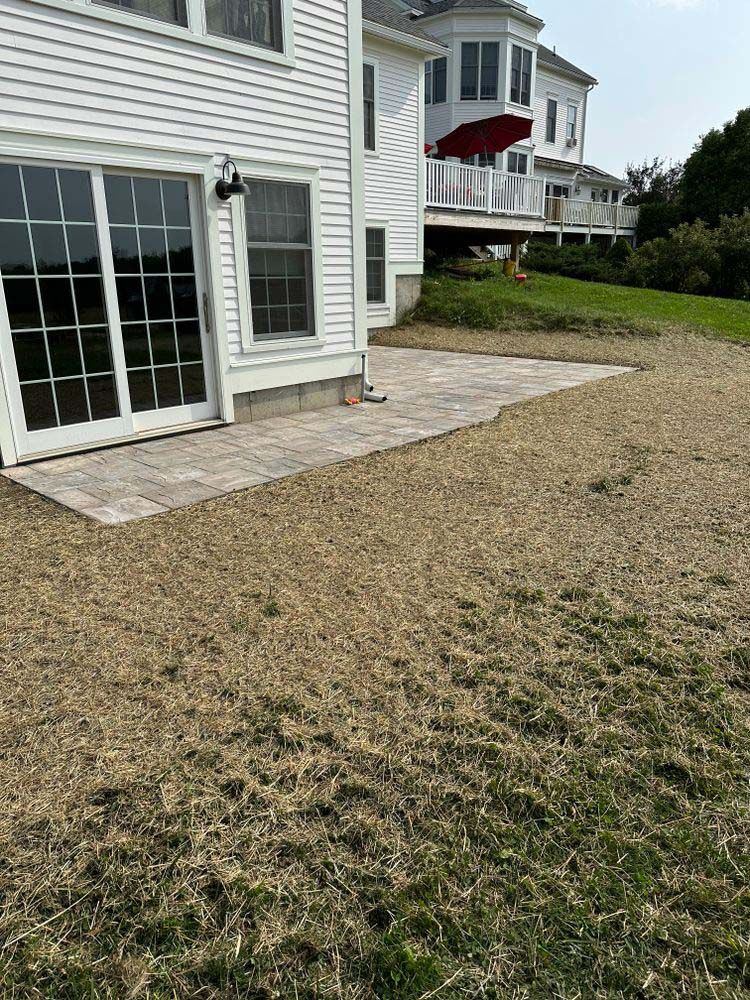A large white house with a patio in front of it.