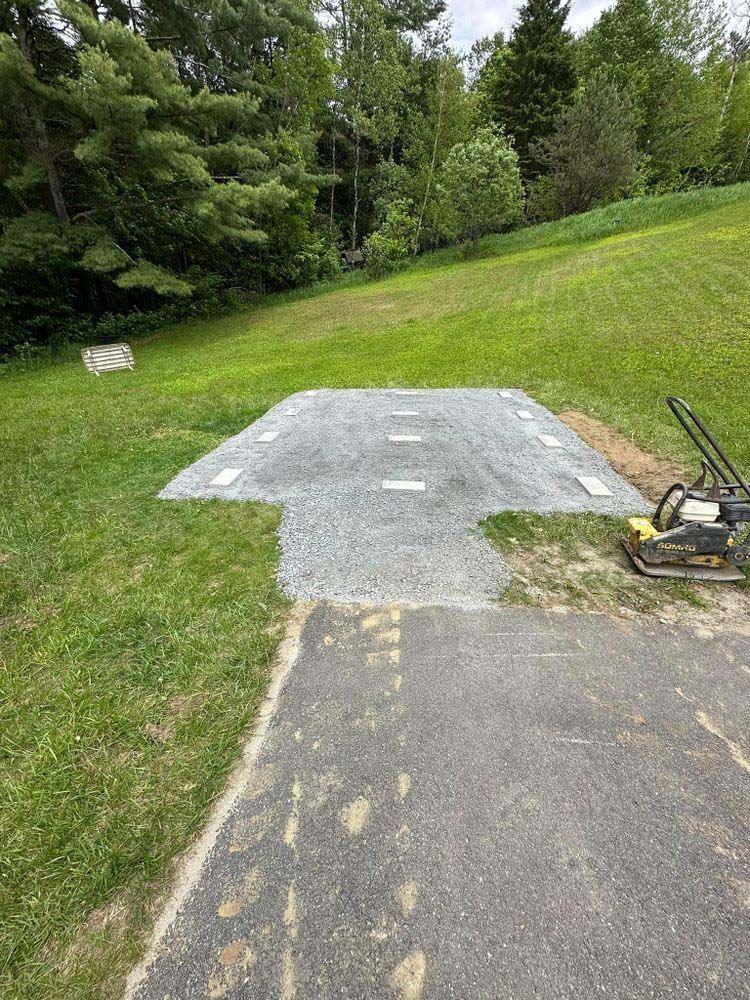 A lawn mower is sitting on the side of a road next to a grassy field.