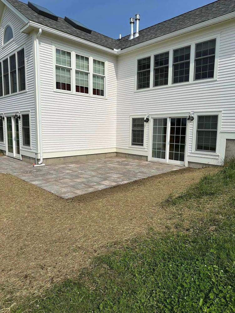 A large white house with a patio in front of it.