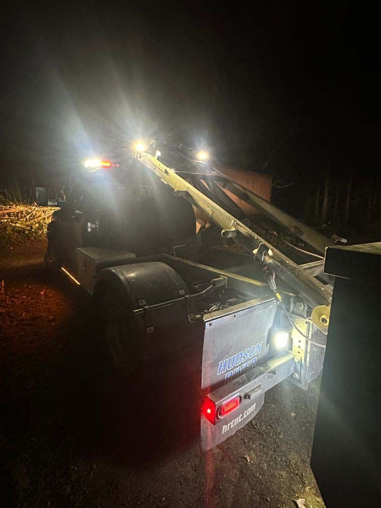 A dump truck is parked on the side of the road at night.