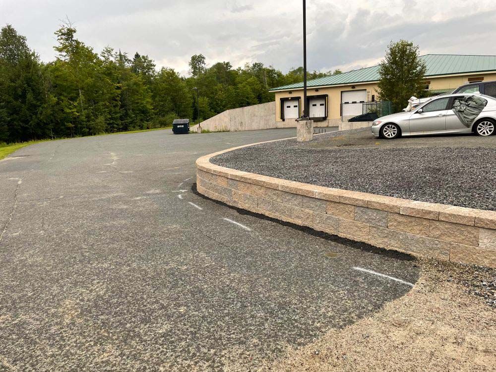 A car is parked in a parking lot next to a building.