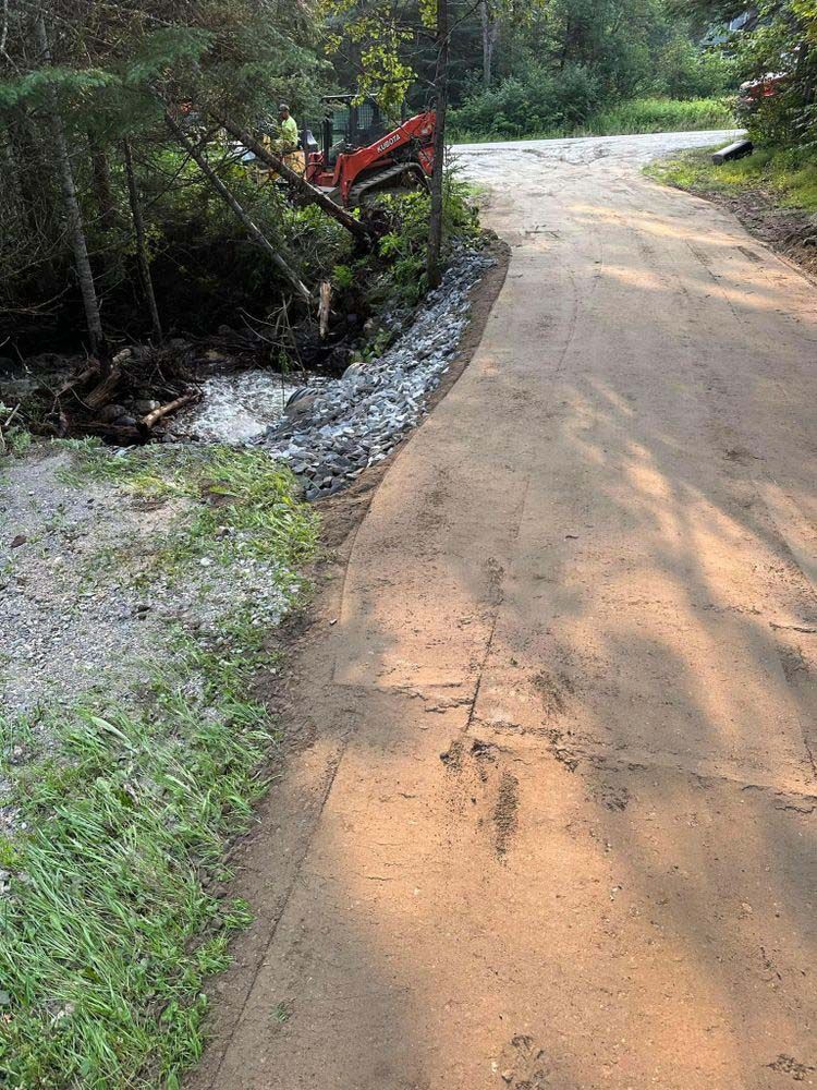 A dirt road with a tractor on the side of it.