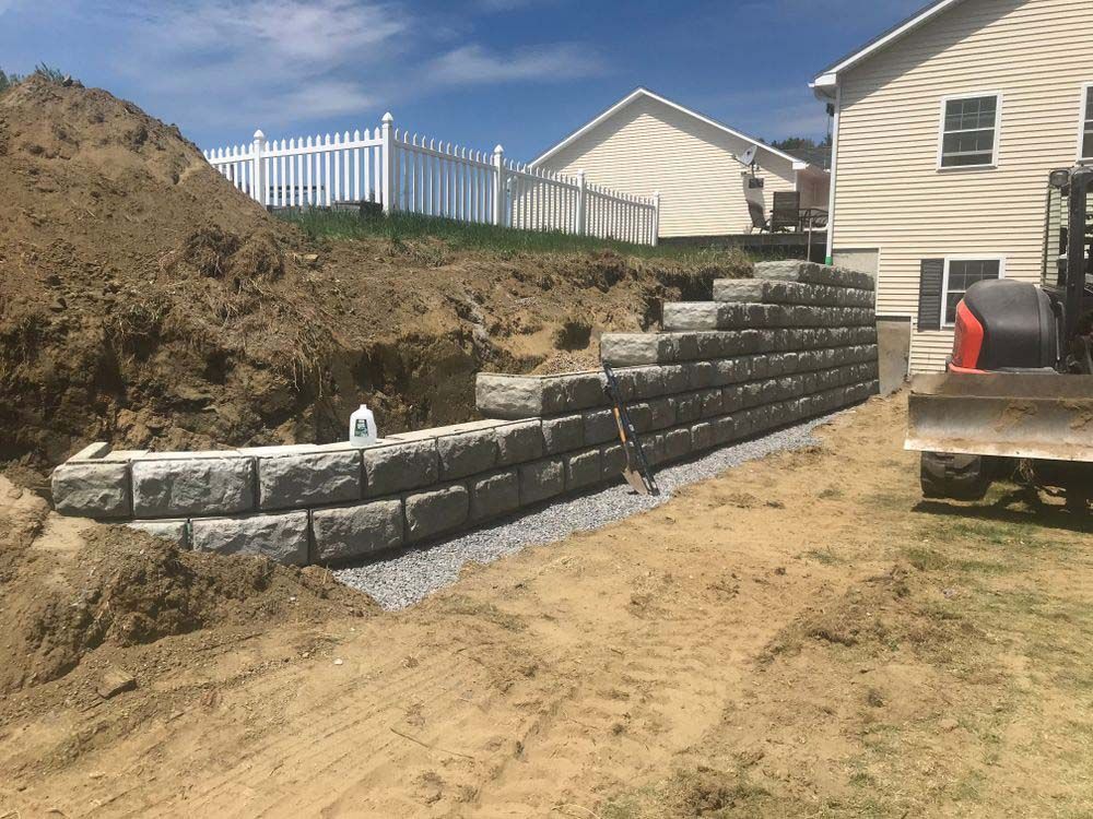 A brick wall is being built in front of a house.