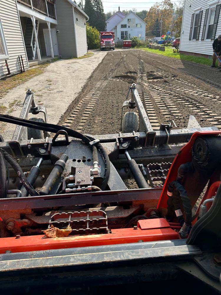 A person is driving a tractor down a dirt road.