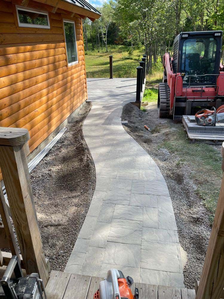 A walkway is being built next to a log cabin.