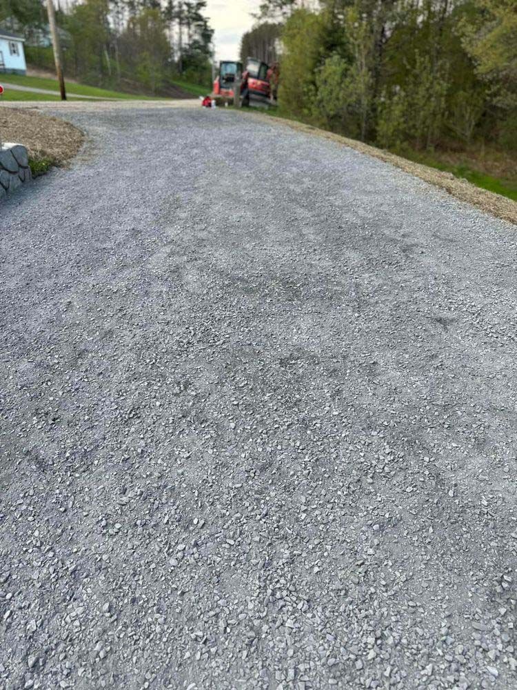 A gravel road with a tractor on the side of it.