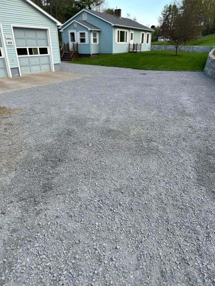 A driveway with gravel in front of a house.