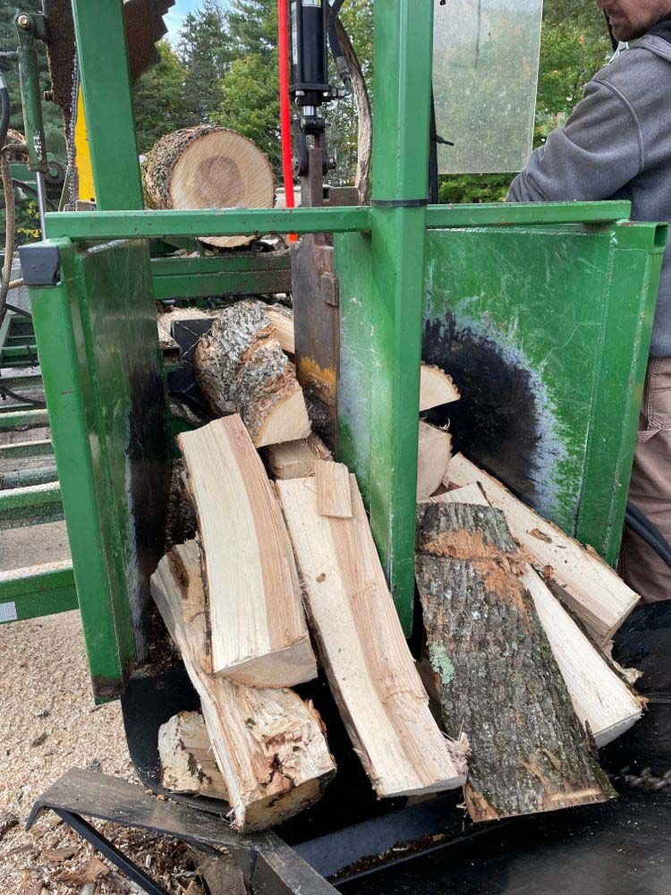 A man is cutting wood with a circular saw.