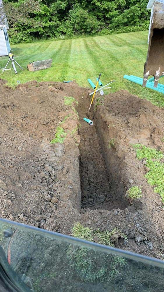 A person is digging a hole in the ground in a yard.