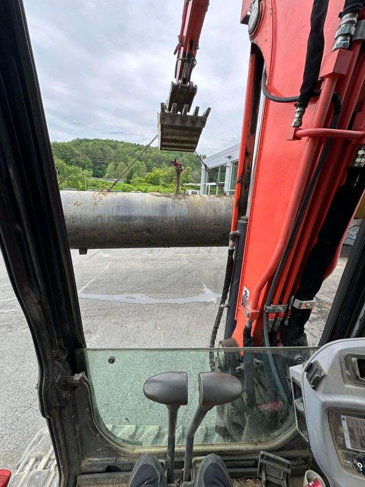 A person is sitting in the driver 's seat of an excavator.
