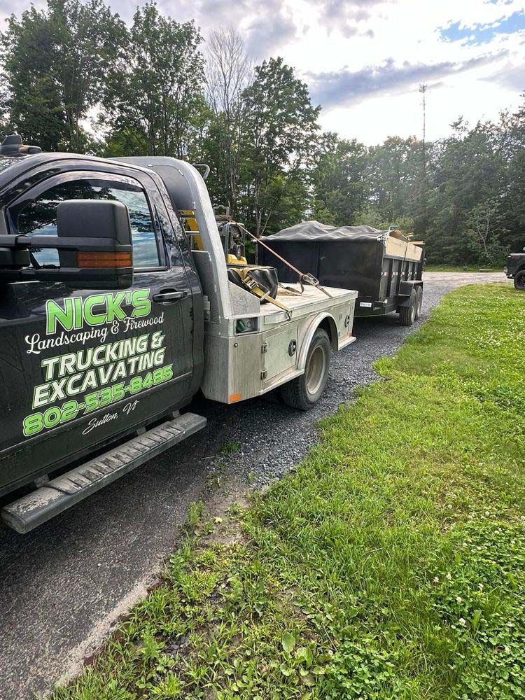 A tow truck with a trailer attached to it is parked on the side of the road.