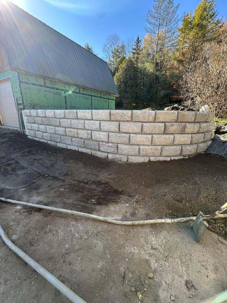 A brick wall is being built in front of a house.