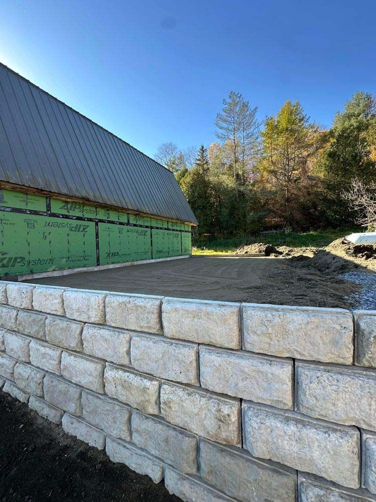 A brick wall is being built in front of a building under construction.
