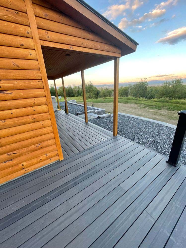 A wooden house with a large deck in front of it.
