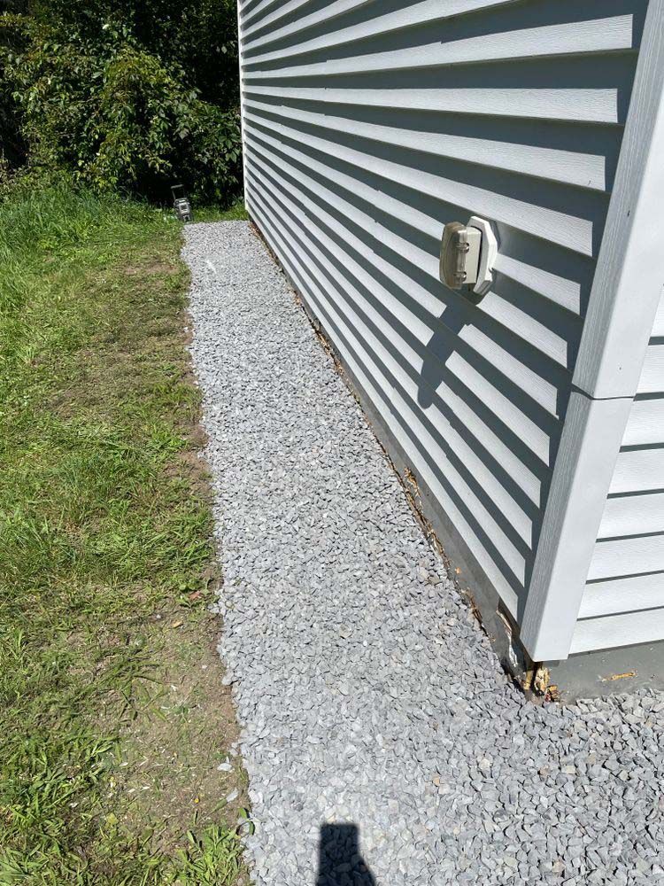 A white house with a gravel walkway leading to it.